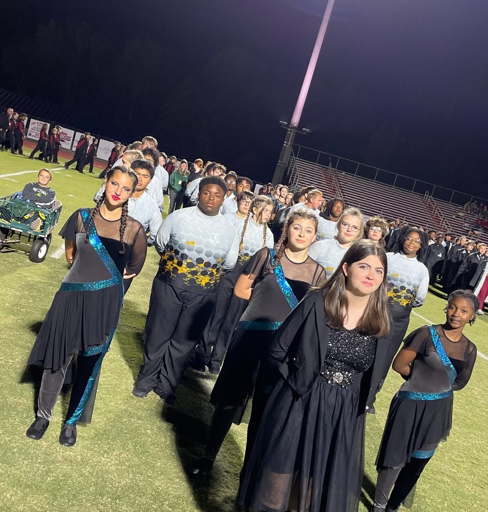 Band students in uniform standing in formation.