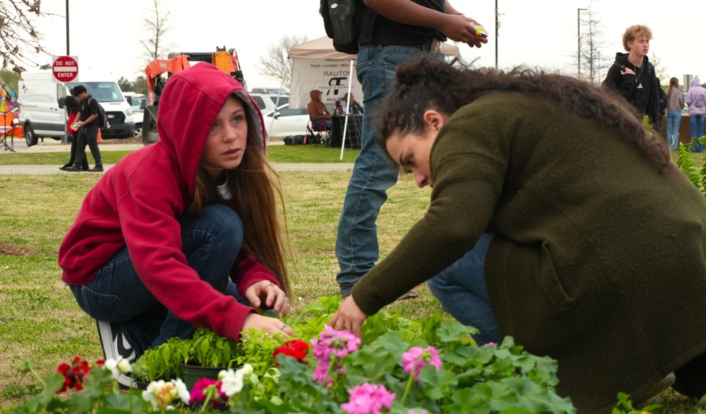 Two students potting flowers.