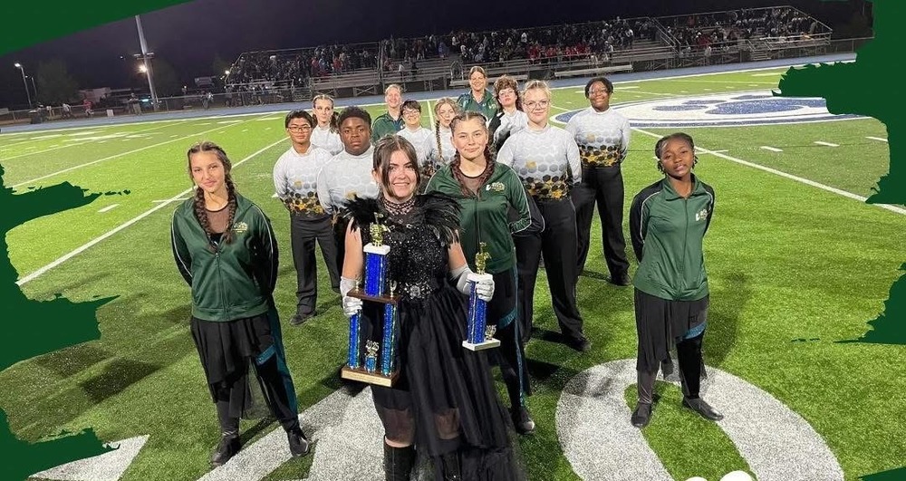 A group of band students holding awards