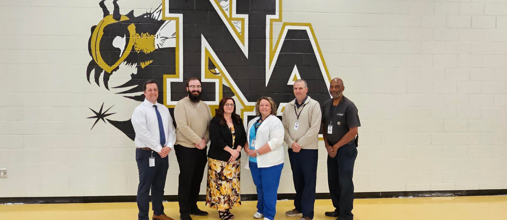 6 Adults standing in front of NAHS Logo