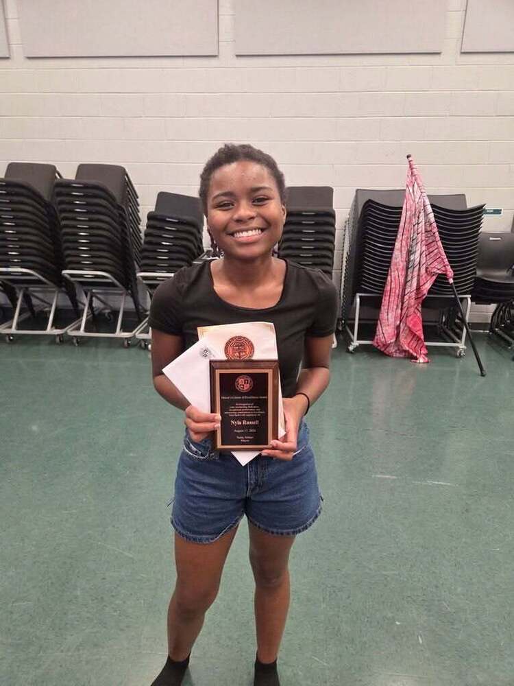 Girl smiling and holding a plaque