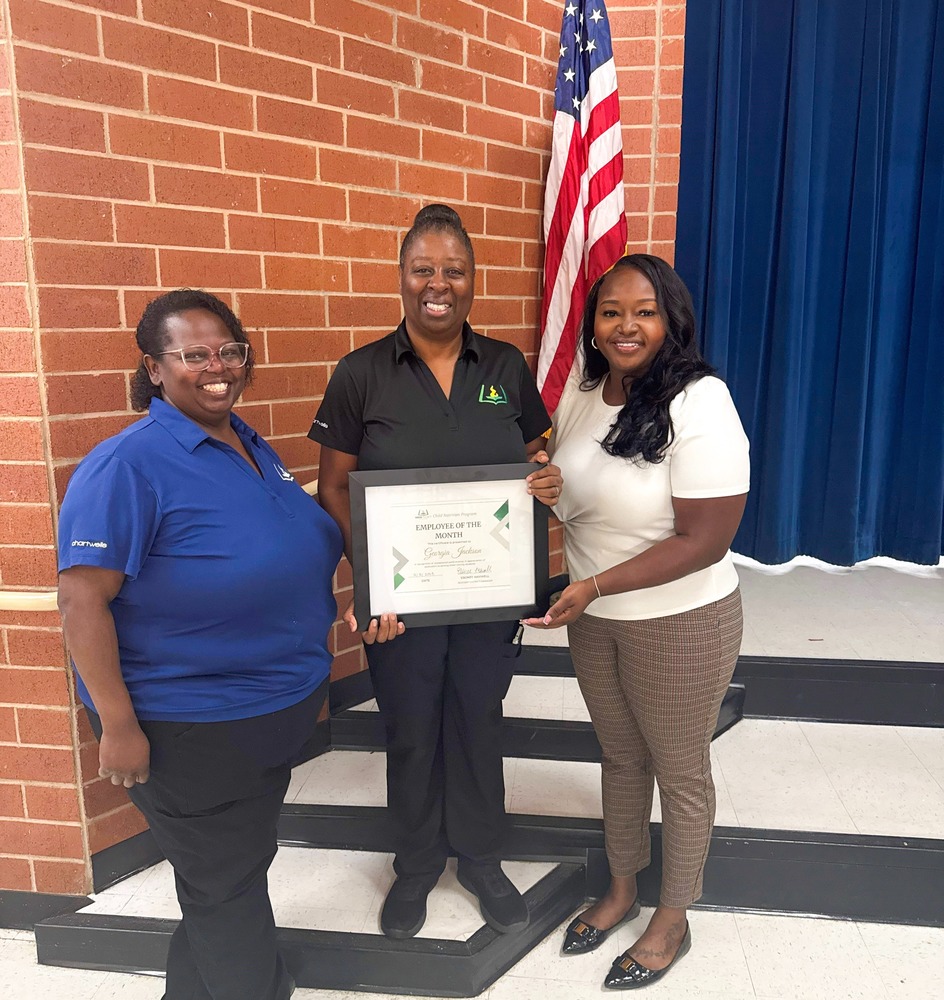 Child Nutrition Professional Georgia Jackson holds a certificate and stands with Child Nutrition Resident District Manager Ebonee Maxwell and Child Nutrition Field Supervisor Bonita Williams