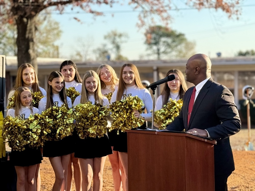 Superintendent Dr. Corey Murphy speaking to cheerleaders during a groundbreaking ceremony.