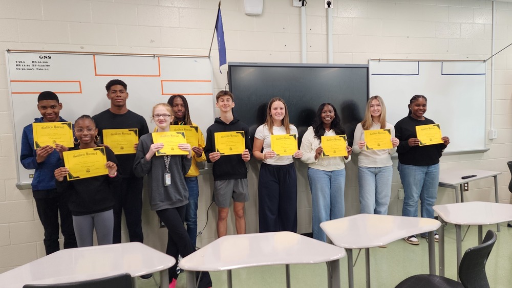 A group of students holding gold award certificates