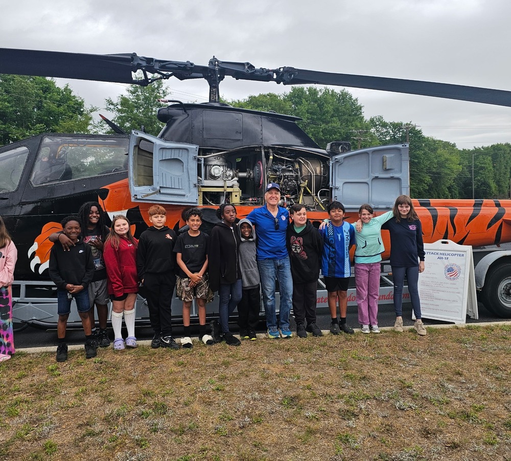 Students standing next to helicopter with owner.