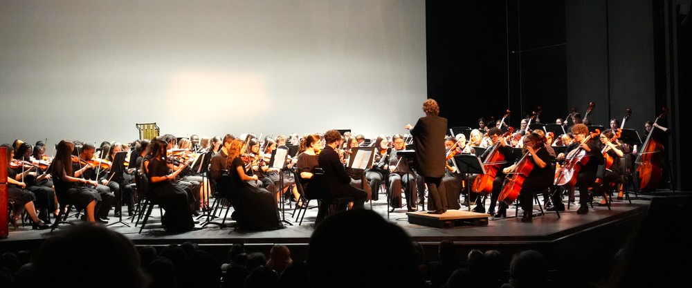 Aiken County High School Symphony Orchestra performs on stage.
