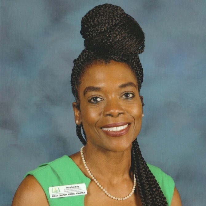 Headshot of Rosalind Key, Business teacher at Aiken High School wearing a green dress.
