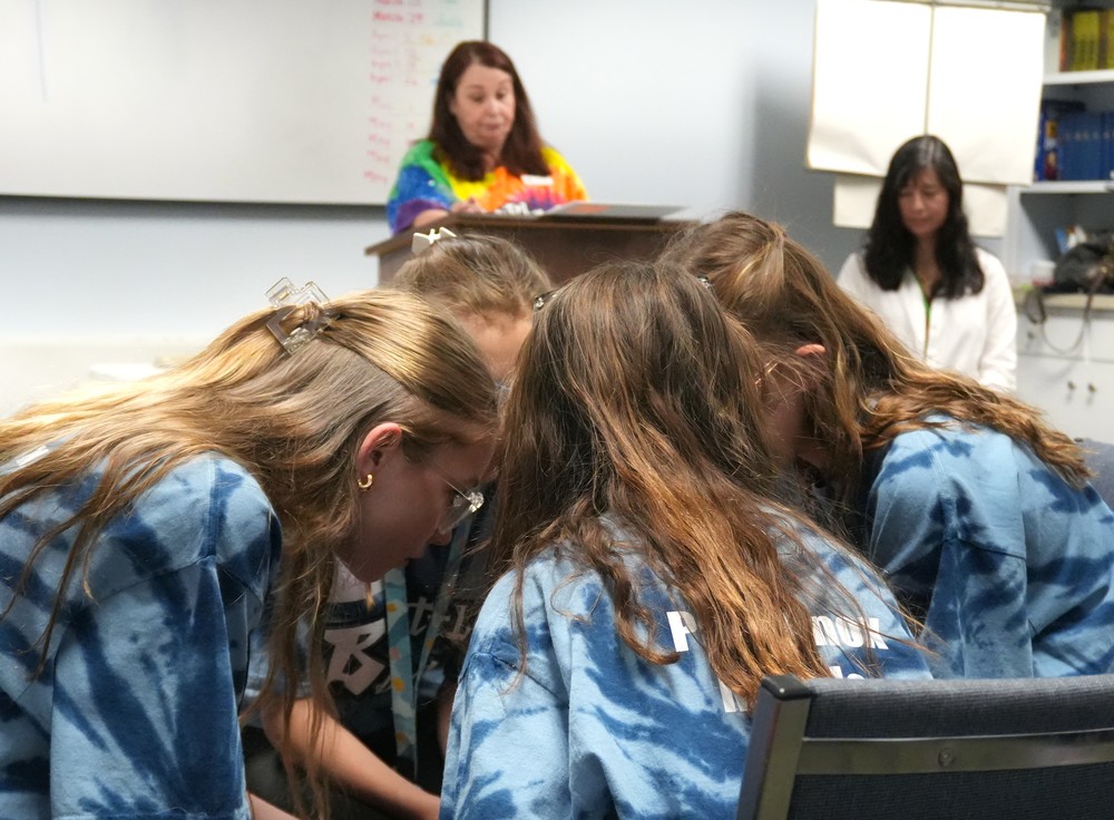 Paul Knox Middle students quietly discuss book answers.