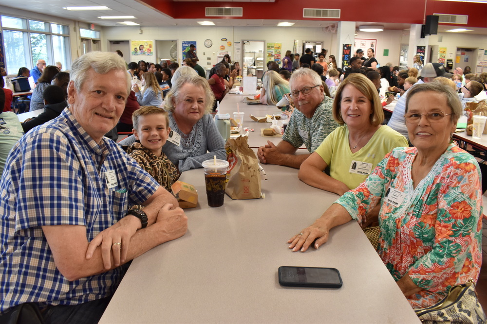 Grandparents and families at lunch with students.