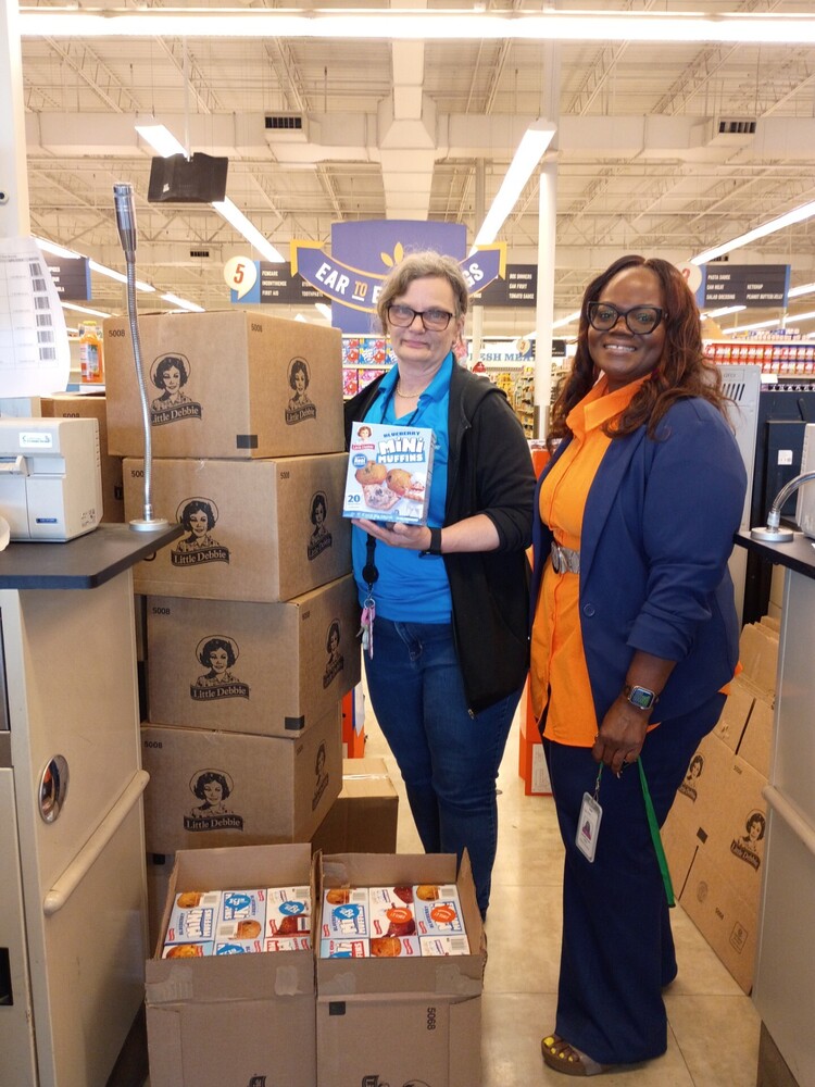 Employee from KJ Grocery and Dr. Johnson standing next to donations.