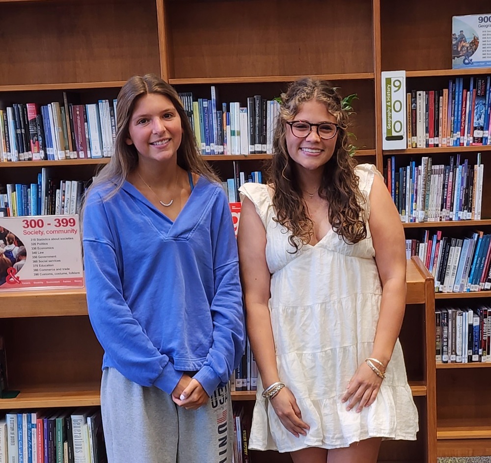 Two students standing together and smiling. 