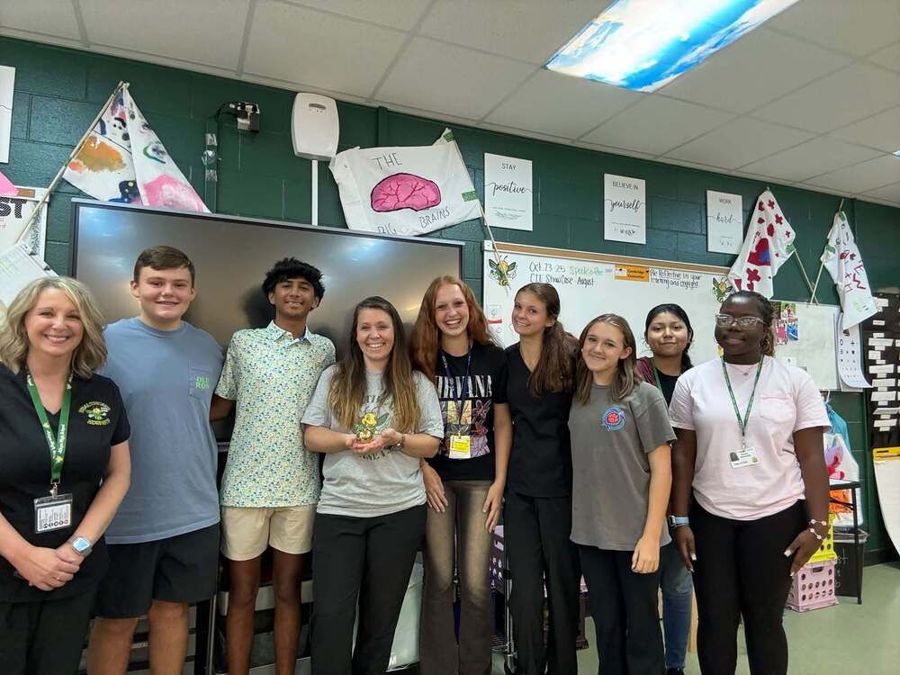 A group of students and two teachers standing together and smiling