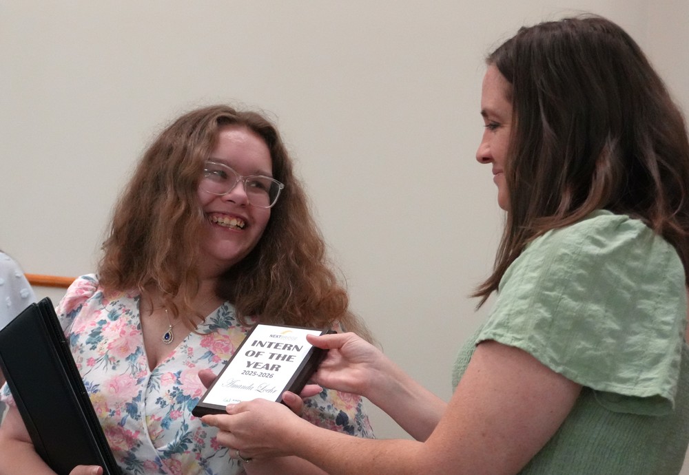 A student receives a plaque for her internship.