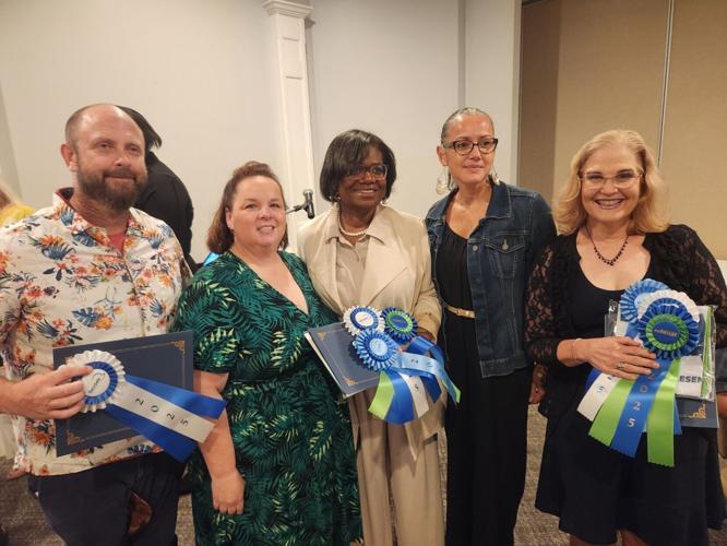 Aiken County Educators holding awards received at a teacher appreciation dinner for culinary arts educators.