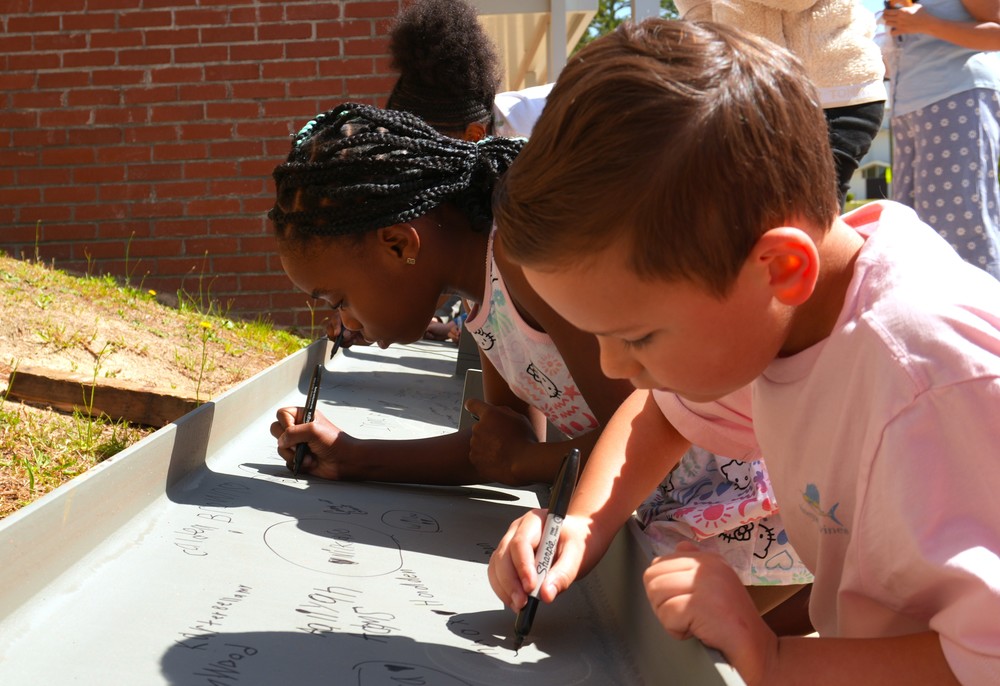 Students at Belvedere sign a construction beam.