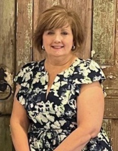 Lou Wakefield in a dress smiling. 