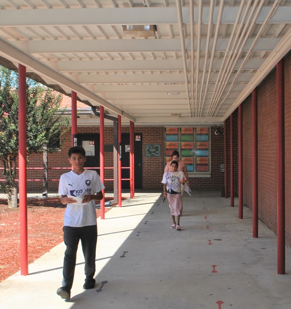 Student and family walking the breezeway to meet teachers for the new year.
