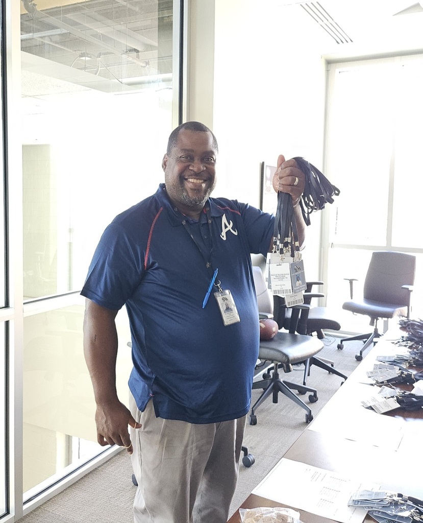 Mr Jackson  holding badges in conference room. 