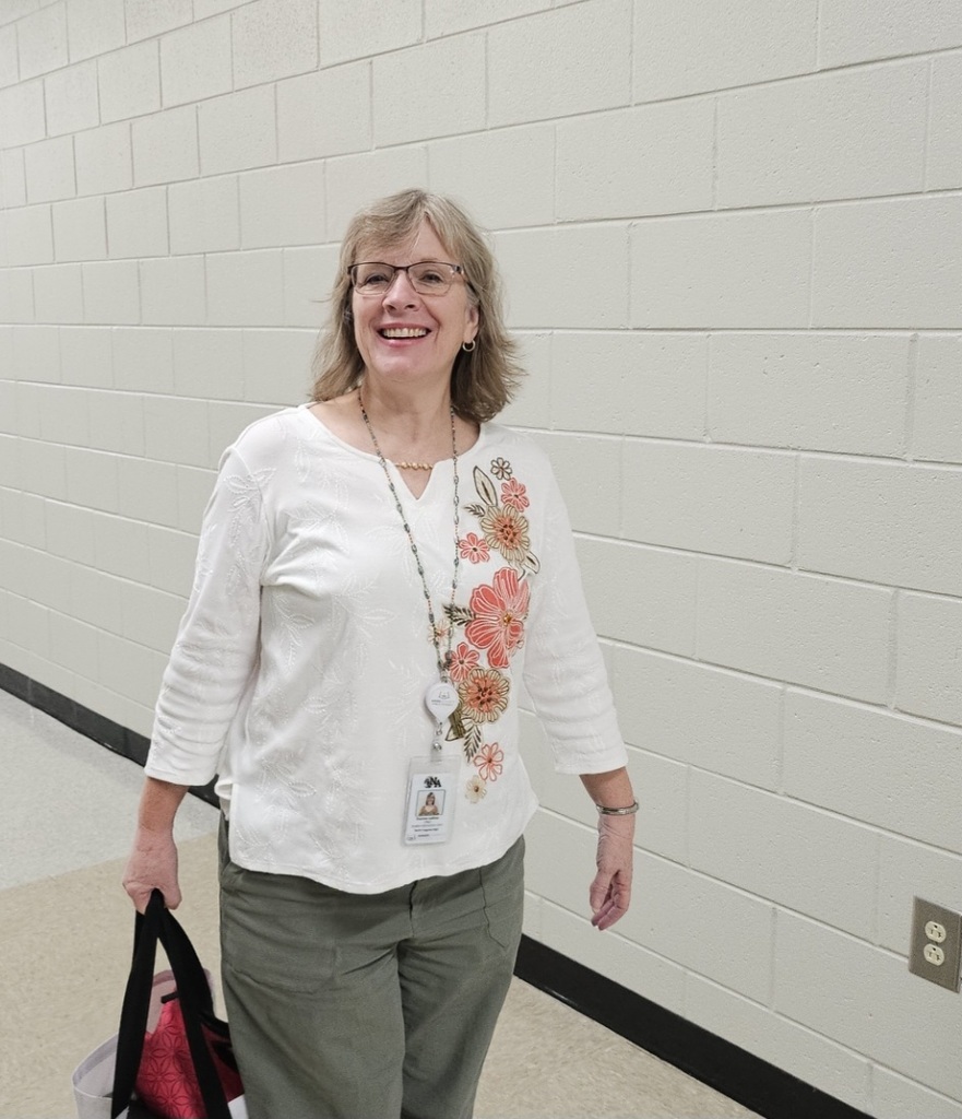 Ms. Leklous standing in hall.