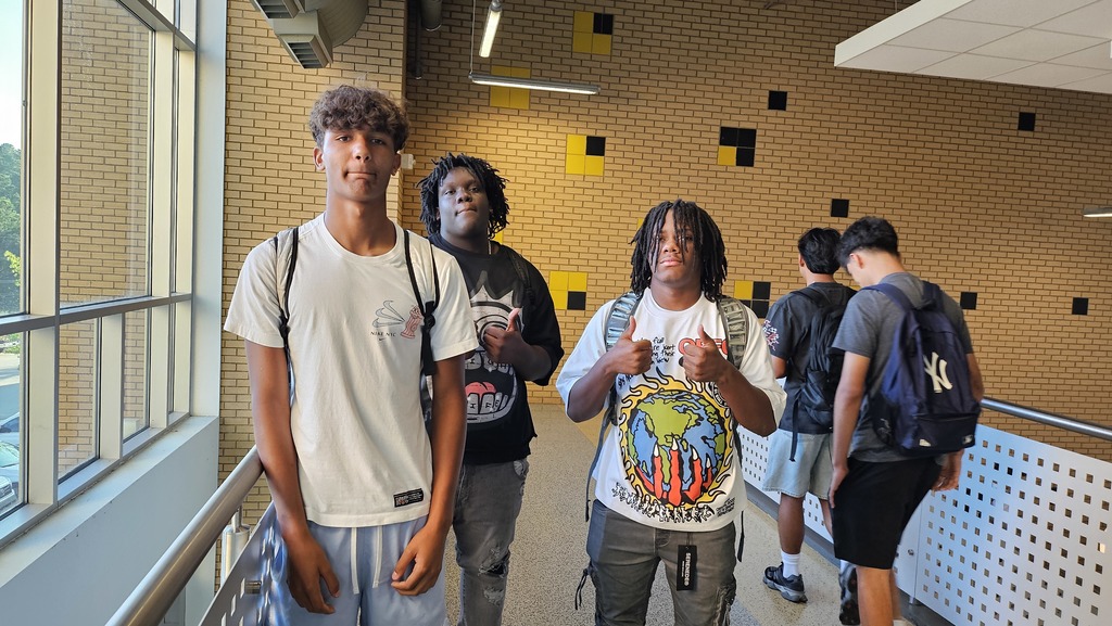 3 Boys in hallway giving thumbs up.