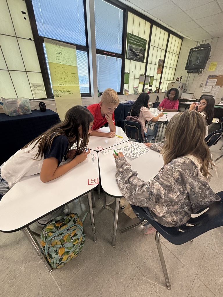 Students working together at desks on a numbered paper