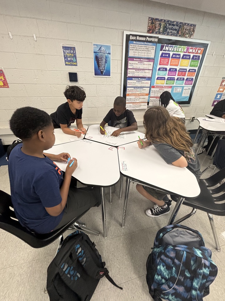 Students working together at desks on a numbered paper