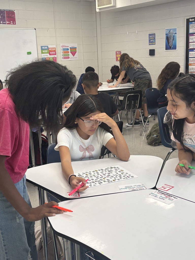Students working together at desks on a numbered paper