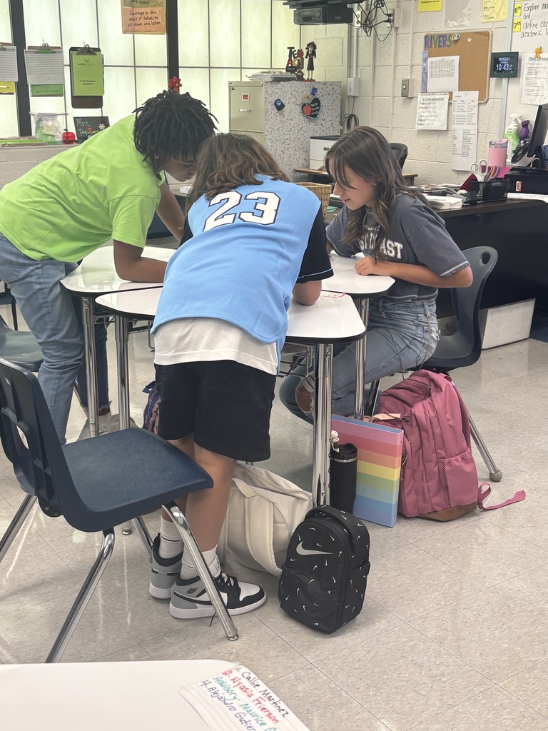 Students working together at desks on a numbered paper