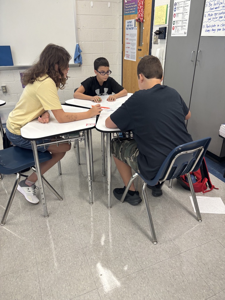 Students working together at desks on a numbered paper