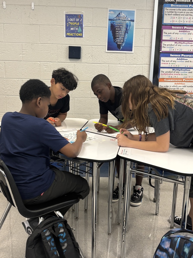 Students working together at desks on a numbered paper