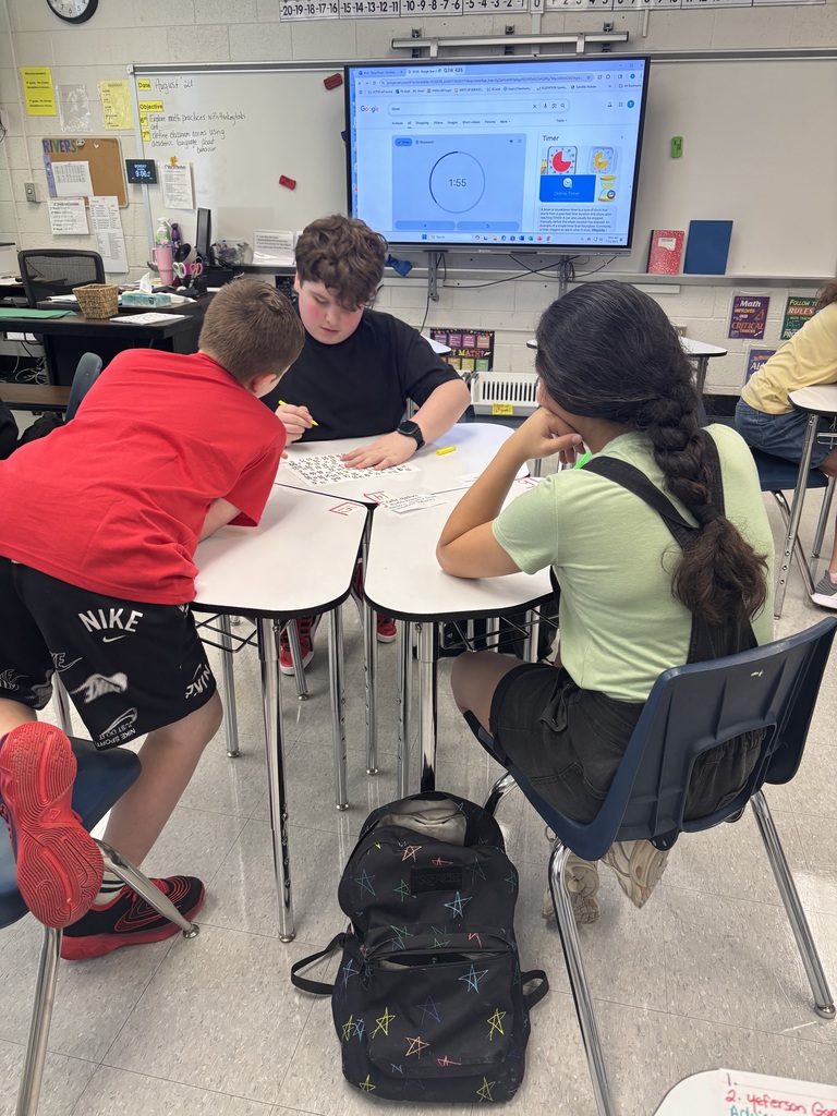 Students working together at desks on a numbered paper