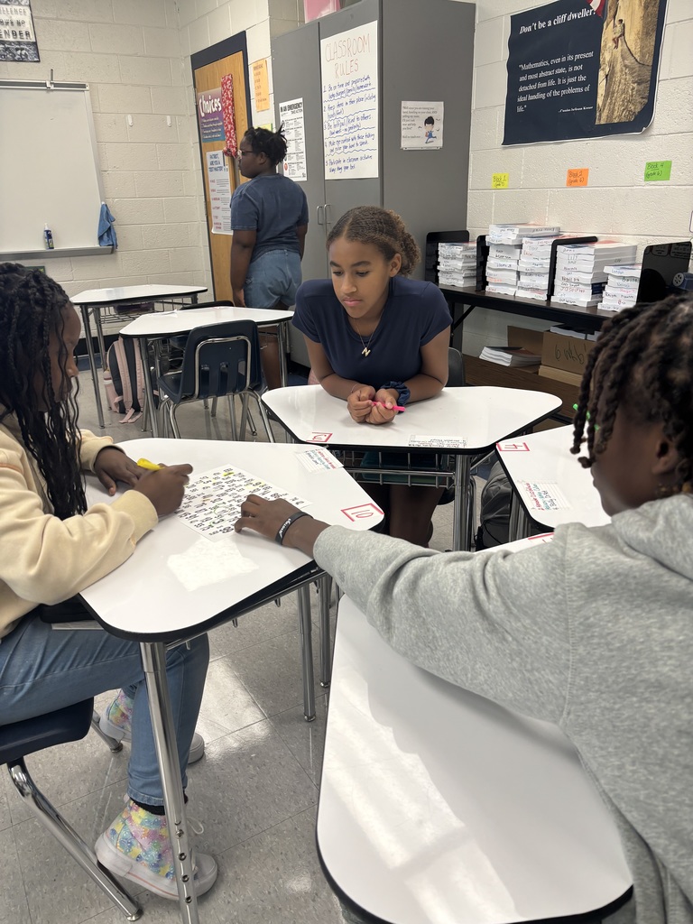 Students working together at desks on a numbered paper