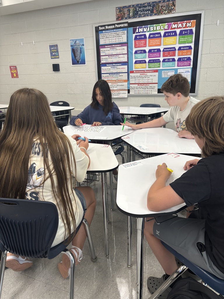 Students working together at desks on a numbered paper