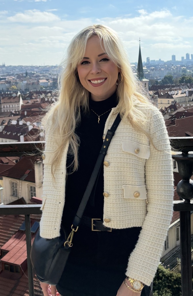Lady smiling in a cream jacket. 