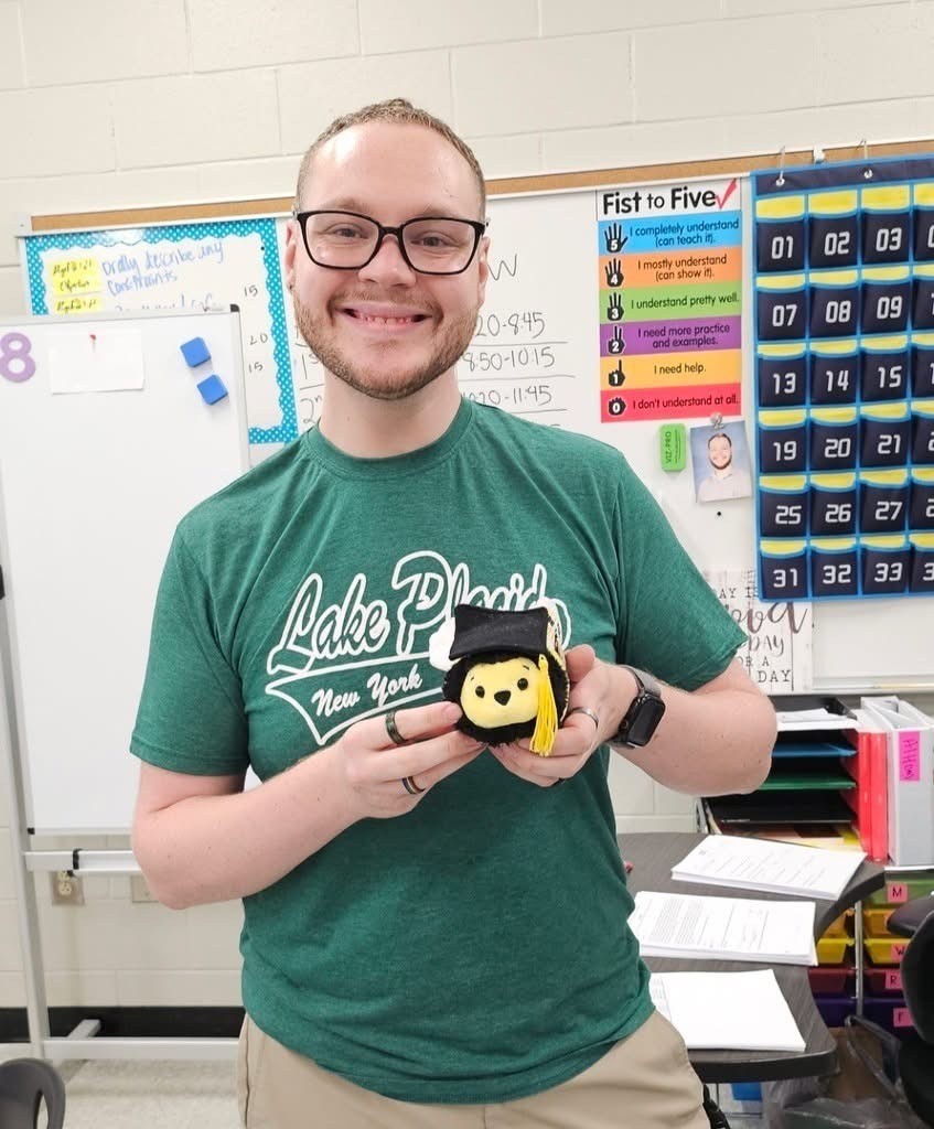 Smiling teacher in a green shirt.