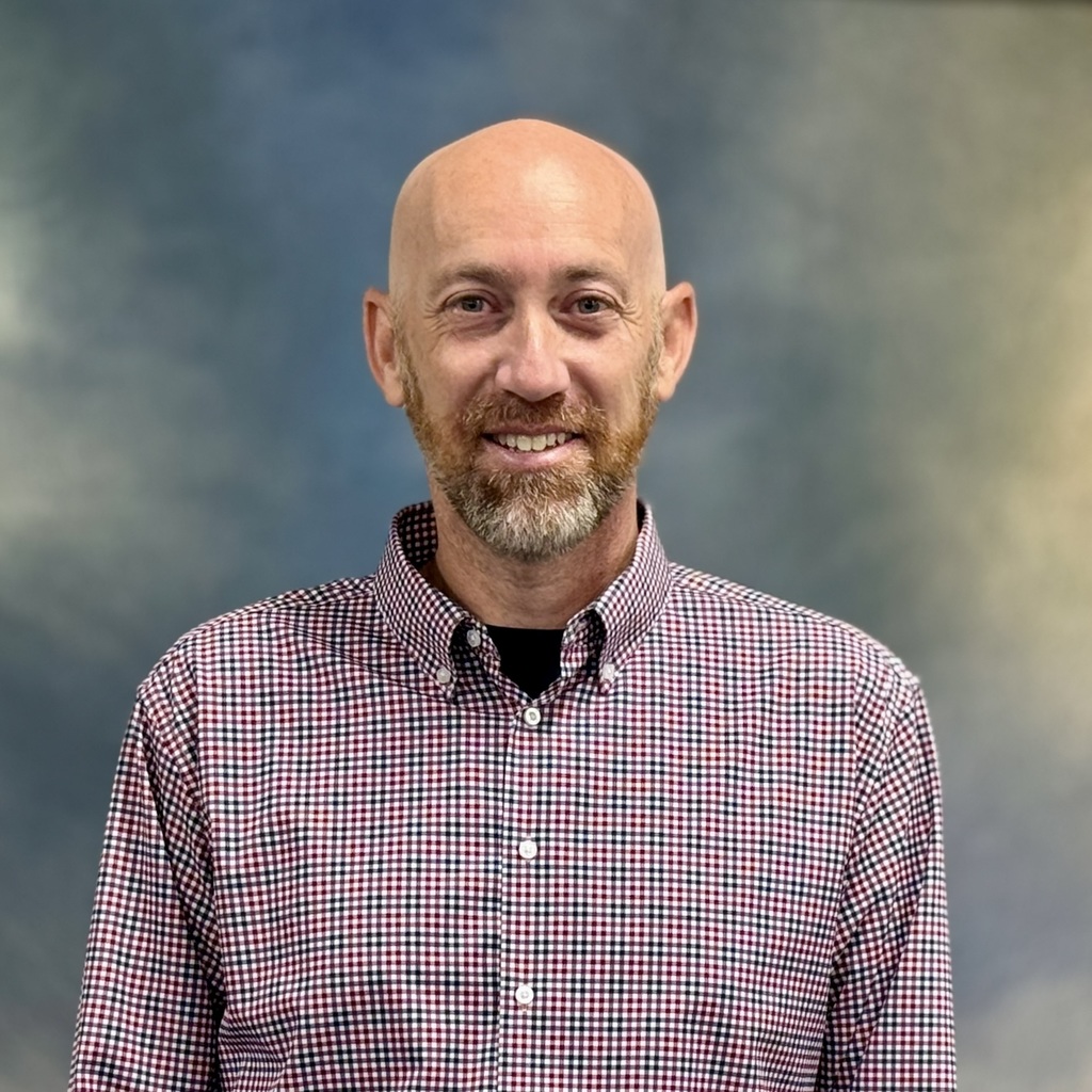Smiling man in a checkered shirt. 