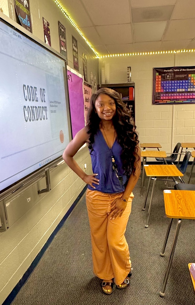 Smiling teacher in a classroom.