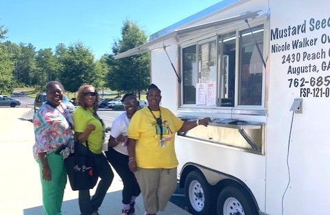 Four ladies standing in front of a food truck