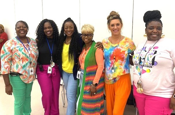 Six ladies standing in the cafeteria