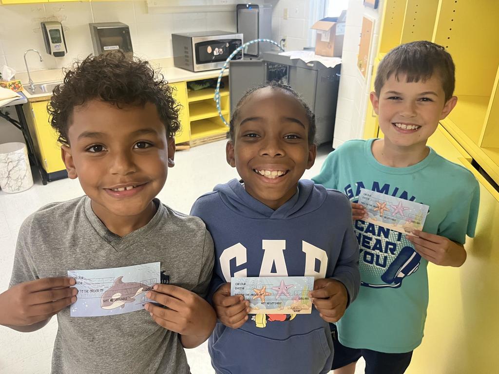 Fourth Grade Students holding "checks"