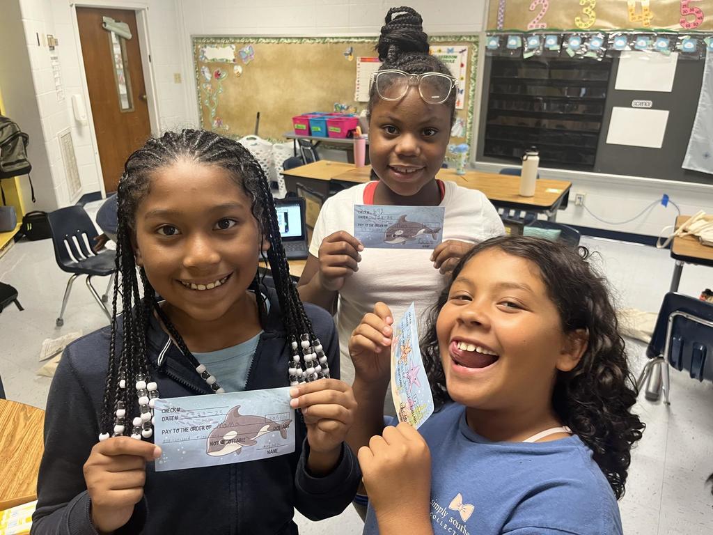 Fourth Grade Students holding "checks"