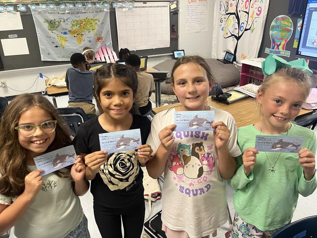 Fourth Grade Students holding "checks"