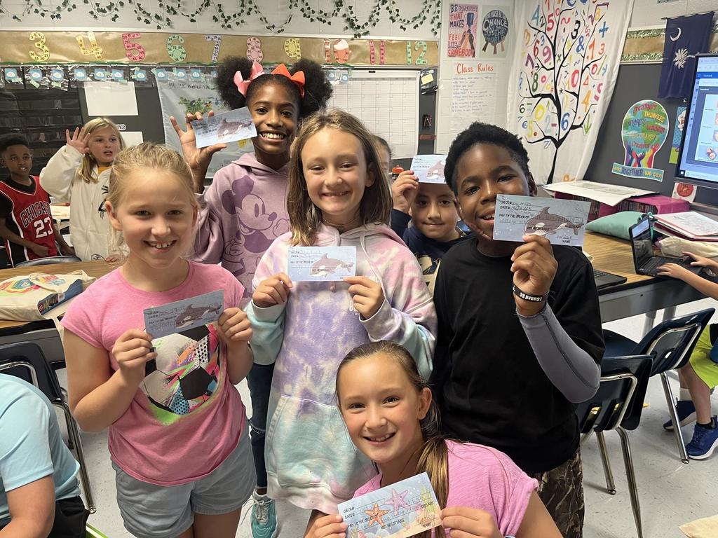 Fourth Grade Students holding "checks"