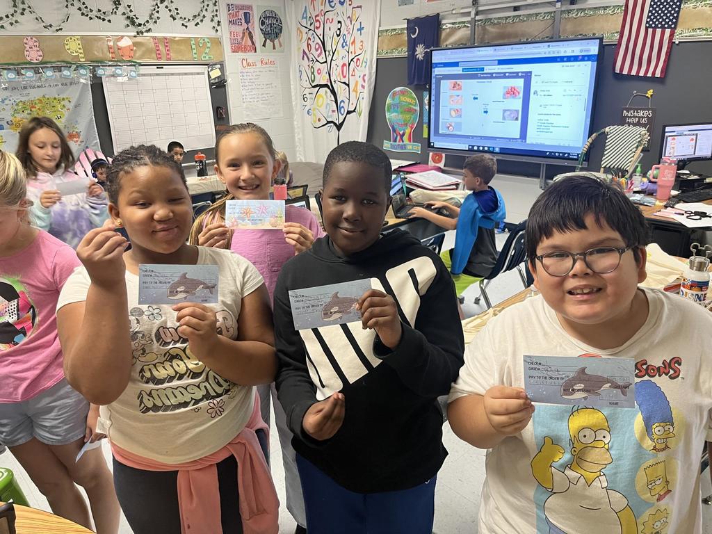 Fourth Grade Students holding "checks"