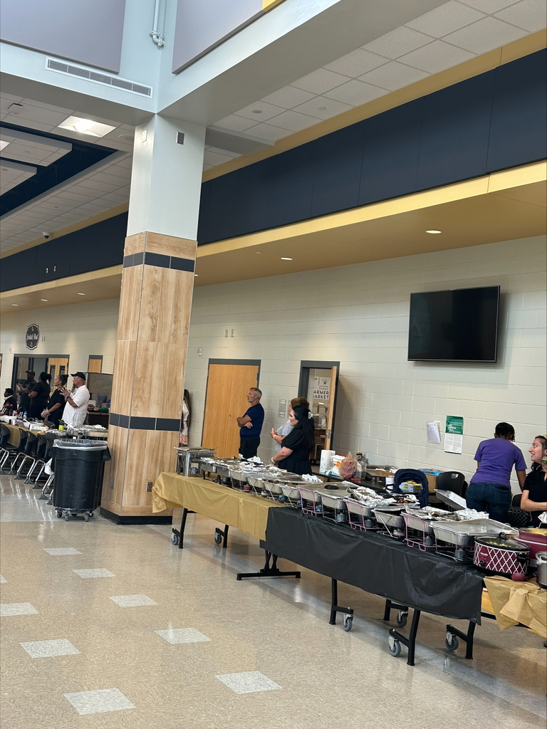 Buffet line at a school with people serving food.
