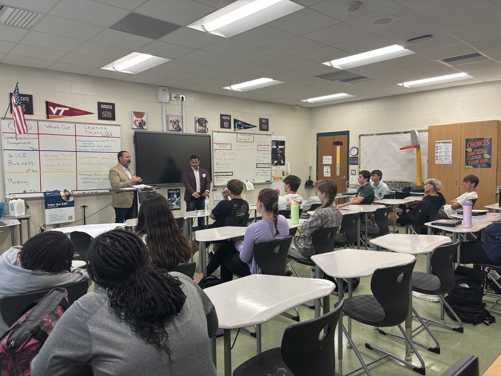 Two Men talking to a class of students
