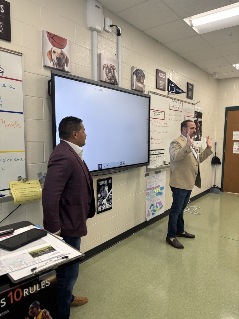 Two men talking to a class in front of a whiteboard
