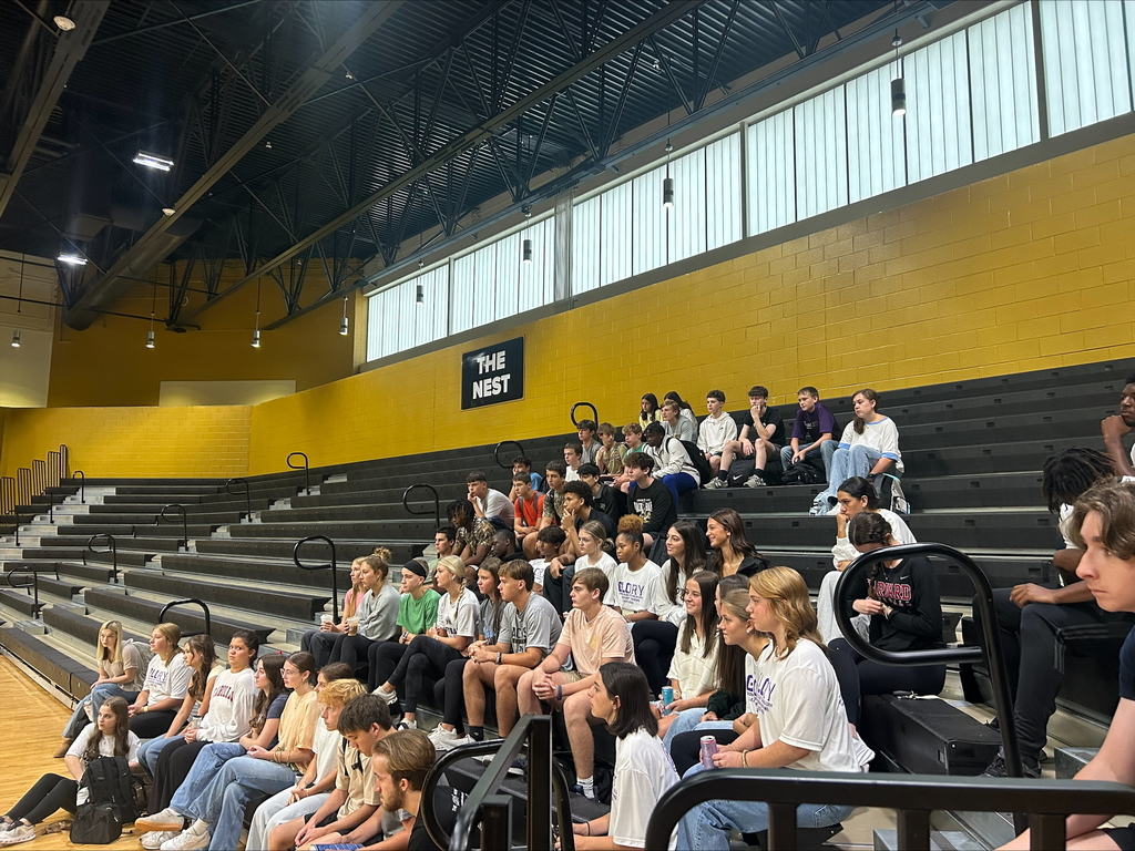 Students sitting on bleachers watching a presentation.