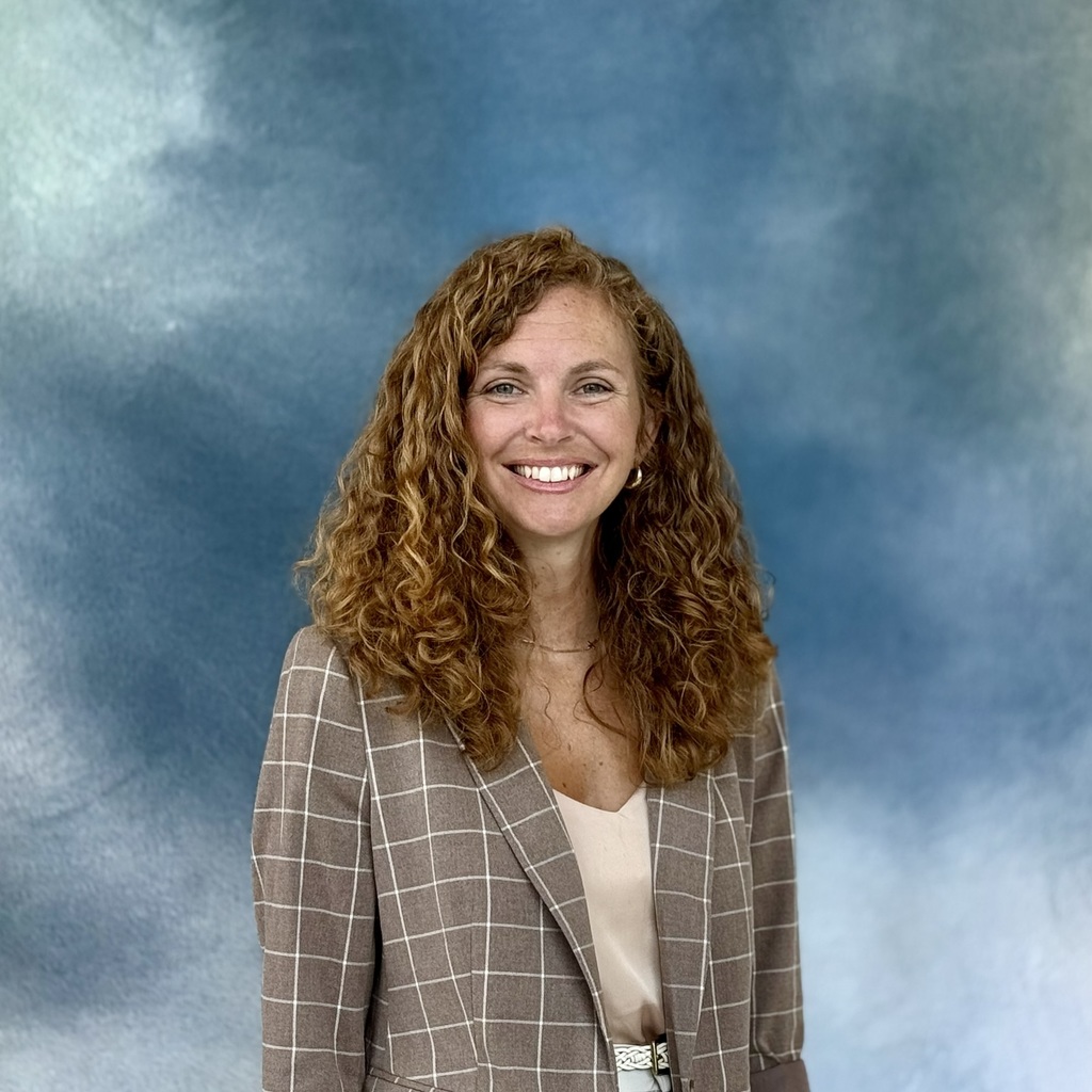 Smiling professional in a checked blazer. 