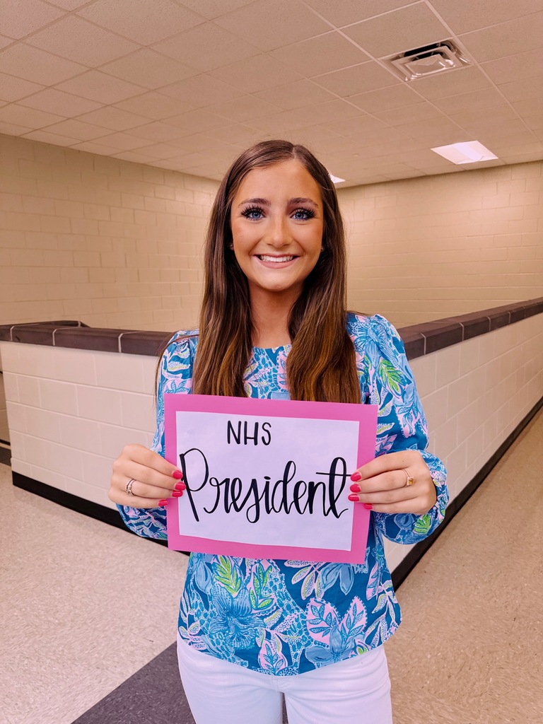 Girl student portrait holding NHS president sign. 